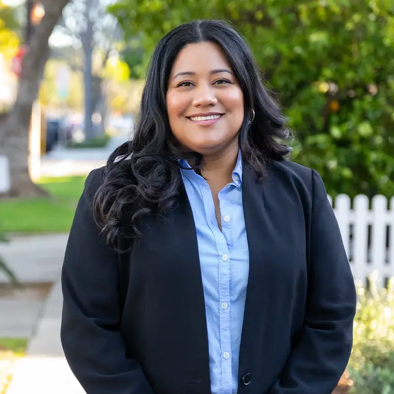 Jessie Lopez smiling in front of a residential street.