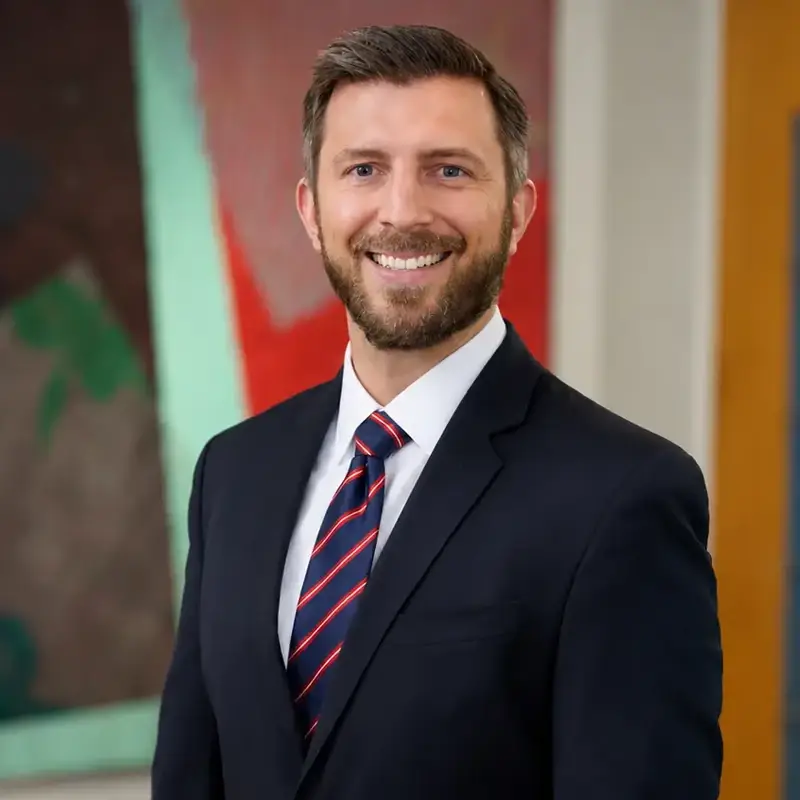 Dan Shimell, smiling while wearing a suit.