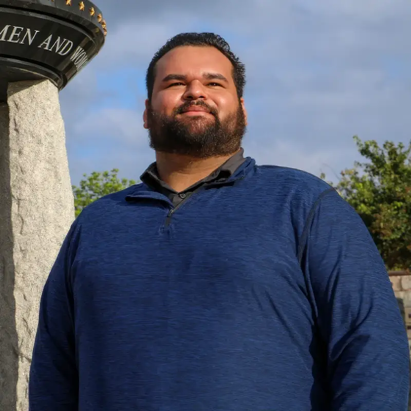 Donald Torres, looking into the distance, in front of a monument.