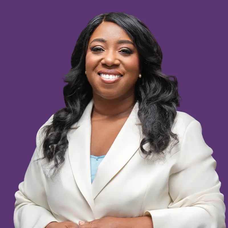 Dr. Leticia Clark, smiling, wearing a white blazer.